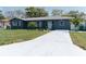 Charming home featuring a well-manicured lawn, freshly painted exterior, and lovely landscaping at 1605 Crown St, Clearwater, FL 33755