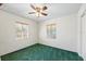 This bright bedroom has two windows, green carpet, and a ceiling fan at 2410 35Th N Ave, St Petersburg, FL 33713