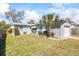 Charming home with a gray exterior, lush green lawn, and a concrete driveway and a palm tree at 2410 35Th N Ave, St Petersburg, FL 33713