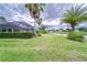 Expansive backyard with lush green grass, a pond view, and a screened lanai at 2926 Spring Hammock Dr, Plant City, FL 33566