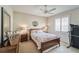 Bedroom features wood furnishings, mirror accent, ceiling fan, and shuttered window at 2926 Spring Hammock Dr, Plant City, FL 33566