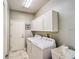 Functional laundry room with washer, dryer, utility sink, and storage cabinets at 2926 Spring Hammock Dr, Plant City, FL 33566