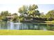 Picturesque pond view with a fountain, lush landscaping, and community signage at 2926 Spring Hammock Dr, Plant City, FL 33566