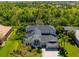 An aerial view of a well-maintained home surrounded by lush landscaping and nearby wooded area at 309 Royal Bonnet Dr, Apollo Beach, FL 33572