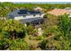 Home with solar panels, screened-in lanai surrounded by mature landscaping, and privacy fence at 309 Royal Bonnet Dr, Apollo Beach, FL 33572