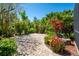 Beautiful backyard featuring a brick paved patio area surrounded by lush landscaping and vibrant flowering plants at 309 Royal Bonnet Dr, Apollo Beach, FL 33572
