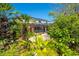 Lush backyard featuring tropical plants, a screened-in lanai, and a serene outdoor space at 309 Royal Bonnet Dr, Apollo Beach, FL 33572