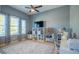 A comfortable bedroom with a ceiling fan, a large area rug, and natural light from a large window at 309 Royal Bonnet Dr, Apollo Beach, FL 33572