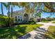 Two-story home showcasing well-maintained lawn, vibrant landscaping, and a welcoming facade at 309 Royal Bonnet Dr, Apollo Beach, FL 33572