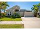 Charming two-story home featuring a well-manicured lawn, complemented by lush tropical landscaping and a spacious three-car garage at 309 Royal Bonnet Dr, Apollo Beach, FL 33572