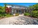 Exterior view of home with lush landscaping, brick patio, and screened enclosure for enjoying the outdoors at 309 Royal Bonnet Dr, Apollo Beach, FL 33572