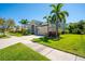 Beautifully landscaped home with a manicured lawn, tall palm trees, and a large driveway at 309 Royal Bonnet Dr, Apollo Beach, FL 33572