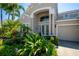 Charming home with manicured landscaping, palm trees, and a welcoming front entrance at 309 Royal Bonnet Dr, Apollo Beach, FL 33572