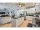 A bright kitchen features modern appliances, an island, granite countertops, and a view into the adjacent Gathering room at 309 Royal Bonnet Dr, Apollo Beach, FL 33572