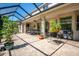 Spacious patio with brick flooring, screened enclosure, with dining table and lush garden surroundings at 309 Royal Bonnet Dr, Apollo Beach, FL 33572