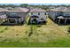 A large backyard with a firepit seating area is nestled between neighboring homes at 3139 Marine Grass Dr, Wimauma, FL 33598