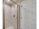 Tiled shower with a glass door and chrome fixtures at 3139 Marine Grass Dr, Wimauma, FL 33598