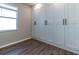 Bedroom with a wall of built-in storage cabinets and wood-look tile flooring at 3139 Marine Grass Dr, Wimauma, FL 33598