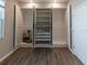 Bedroom with open closet featuring shelving, drawers and wood-look tile flooring at 3139 Marine Grass Dr, Wimauma, FL 33598
