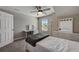 Well lit bedroom with a ceiling fan, plush carpeting, and a white dresser and desk area at 3139 Marine Grass Dr, Wimauma, FL 33598