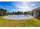 Beautiful outdoor pool with a sundeck and a grassy area, and the clubhouse in the background at 3139 Marine Grass Dr, Wimauma, FL 33598