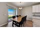 Bright dining area features a wood table with lake views through sliding glass doors at 3139 Marine Grass Dr, Wimauma, FL 33598