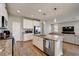 Bright kitchen with granite counters, stainless appliances, and an island offering barstool seating and integrated dishwasher at 3139 Marine Grass Dr, Wimauma, FL 33598