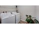 Bright laundry room with a washer and dryer and some storage space, featuring wood look tile flooring at 3139 Marine Grass Dr, Wimauma, FL 33598