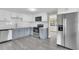 Modern kitchen featuring stainless steel appliances, white subway tile, and light gray laminate flooring at 3718 N 32Nd St, Tampa, FL 33610