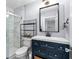 Bathroom featuring marble tile shower, blue vanity, and modern mirror providing a spa-like experience at 37420 Meridian Ave, Dade City, FL 33525