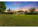 Charming one-story home with expansive front lawn under a colorful sunset at 37420 Meridian Ave, Dade City, FL 33525
