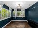 A sun room painted a dark teal color with lots of natural light and hard wood flooring at 37420 Meridian Ave, Dade City, FL 33525