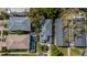 Aerial view showcasing a neighborhood with well-maintained homes, mature trees, and a community pool for residents at 409 S Arrawana Ave, Tampa, FL 33609
