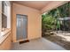 Covered back patio featuring back door access to home and an outdoor pergola and tropical landscaping at 409 S Arrawana Ave, Tampa, FL 33609