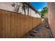 Back yard features a wood fence with a stone walkway along side the home at 409 S Arrawana Ave, Tampa, FL 33609