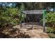 Beautiful backyard features a wooden deck with a pergola surrounded by lush tropical foliage at 409 S Arrawana Ave, Tampa, FL 33609