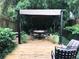 Outdoor deck features dining table and seating perfect for entertaining, surrounded by lush tropical foliage at 409 S Arrawana Ave, Tampa, FL 33609