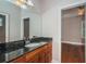 A bathroom features a sink, dark stone countertop, and wood cabinets at 409 S Arrawana Ave, Tampa, FL 33609