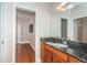 A bathroom features a sink, dark stone countertop, and wood cabinets at 409 S Arrawana Ave, Tampa, FL 33609