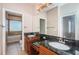Bathroom with double vanity, granite countertop, and framed mirror on tile floor at 409 S Arrawana Ave, Tampa, FL 33609