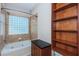 A tiled bathroom featuring a large tub and a glass block window at 409 S Arrawana Ave, Tampa, FL 33609
