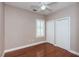 A modest bedroom features wood floors, neutral walls, window shutters, and a closet at 409 S Arrawana Ave, Tampa, FL 33609