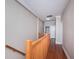 Hallway with hardwood floors, neutral walls, and wood railing leading to other areas of the home at 409 S Arrawana Ave, Tampa, FL 33609