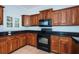 Updated kitchen featuring black appliances, granite countertops, and wood cabinets at 409 S Arrawana Ave, Tampa, FL 33609