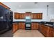 Updated kitchen featuring black appliances, granite countertops, wood cabinets and tile floors at 409 S Arrawana Ave, Tampa, FL 33609