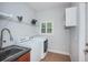 Laundry room featuring tile floors, a utility sink, and white washer and dryer at 409 S Arrawana Ave, Tampa, FL 33609