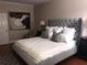 Elegant primary bedroom with a tufted headboard, neutral walls and a painting at 409 S Arrawana Ave, Tampa, FL 33609