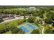 Aerial view of tennis courts, basketball court, lake, and surrounding area at 4160 Pinelake Ln # 201, Tampa, FL 33618
