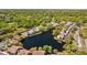 Aerial view of condos encircling a serene lake, surrounded by lush greenery and providing a peaceful living environment at 4160 Pinelake Ln # 201, Tampa, FL 33618