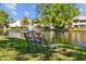An ornate bench faces a tranquil pond and fountain, complemented by lush landscaping surrounding lakeside condos at 4160 Pinelake Ln # 201, Tampa, FL 33618